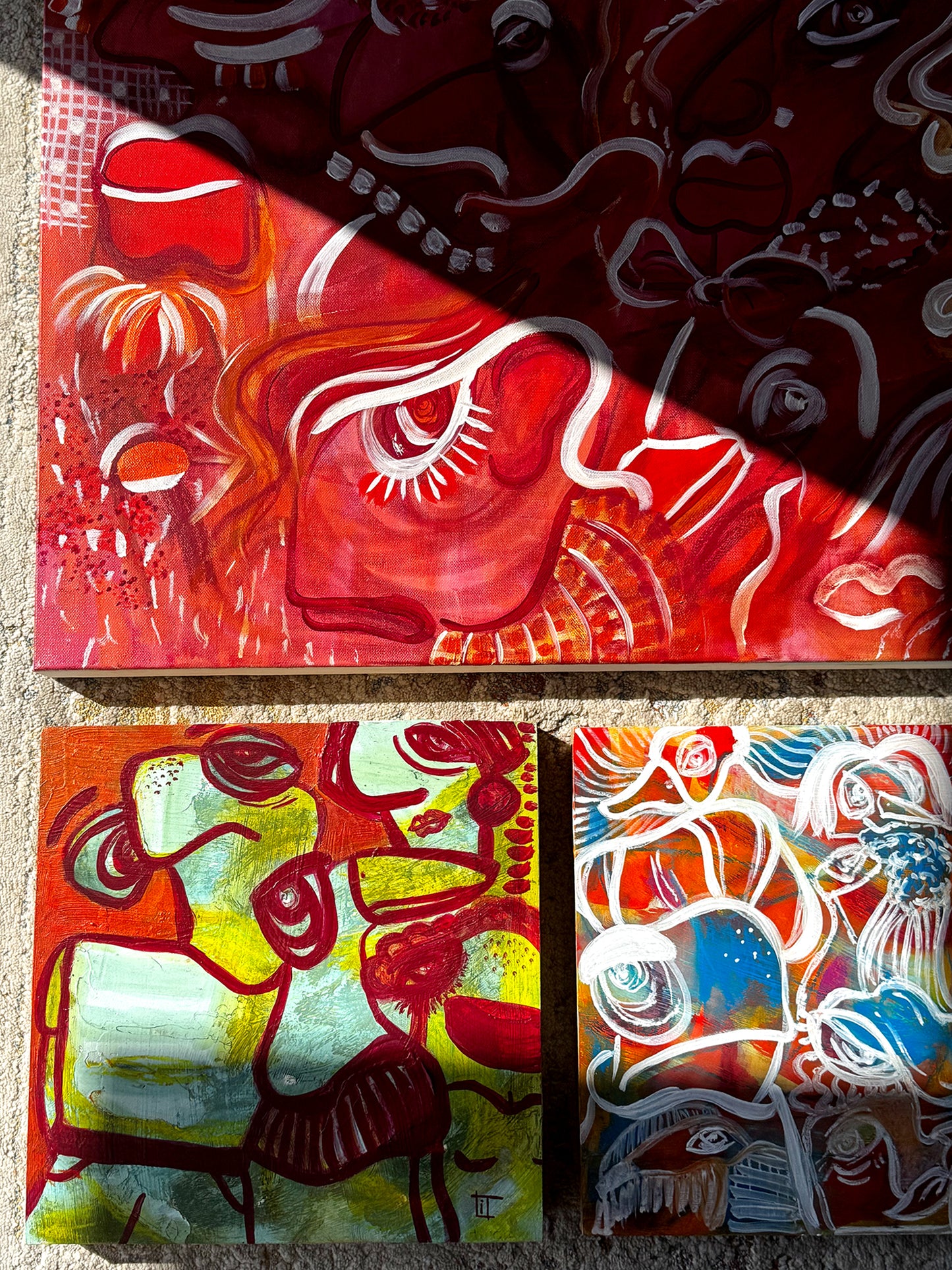 Three abstract artworks on a textured surface. Abstract expressionist original artworks  by Studio Thicia Luiza