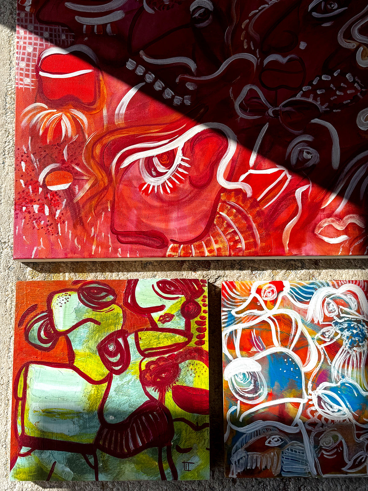 Three abstract artworks on a textured surface. Abstract expressionist original artworks  by Studio Thicia Luiza