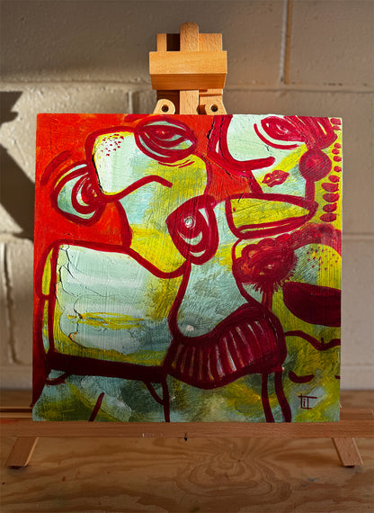 Abstract painting on a wooden easel against a textured wall. In turquoise, green, orange and red by Studio Thicia Luiza